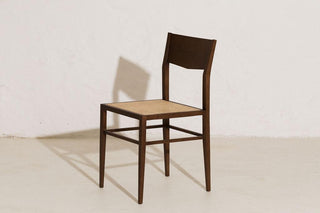 BASMATI wooden side chair with a woven cane seat, front three-quarter view.