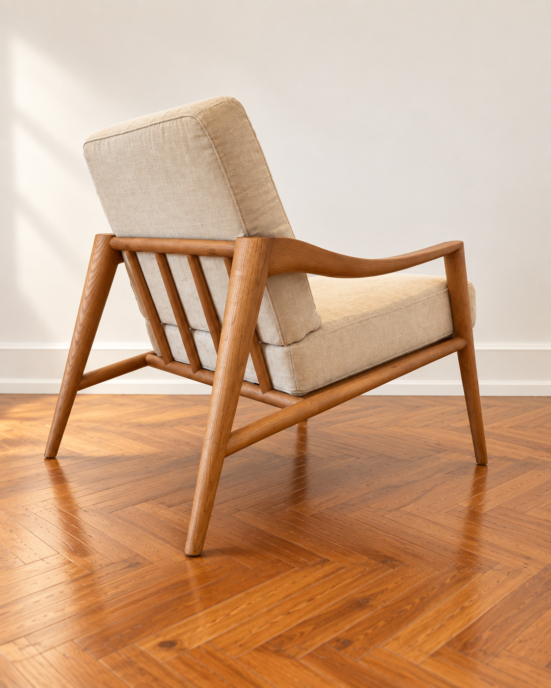 Rear three-quarter view of the GLORIA lounge chair showing its wooden frame.