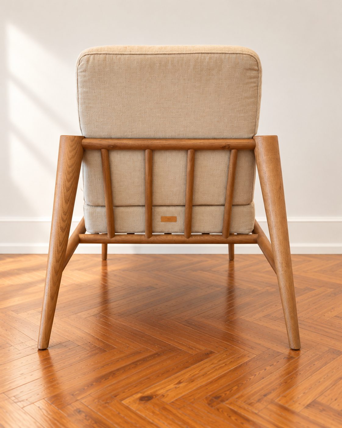 Rear view of the GLORIA lounge chair with an upholstered back and wooden frame.